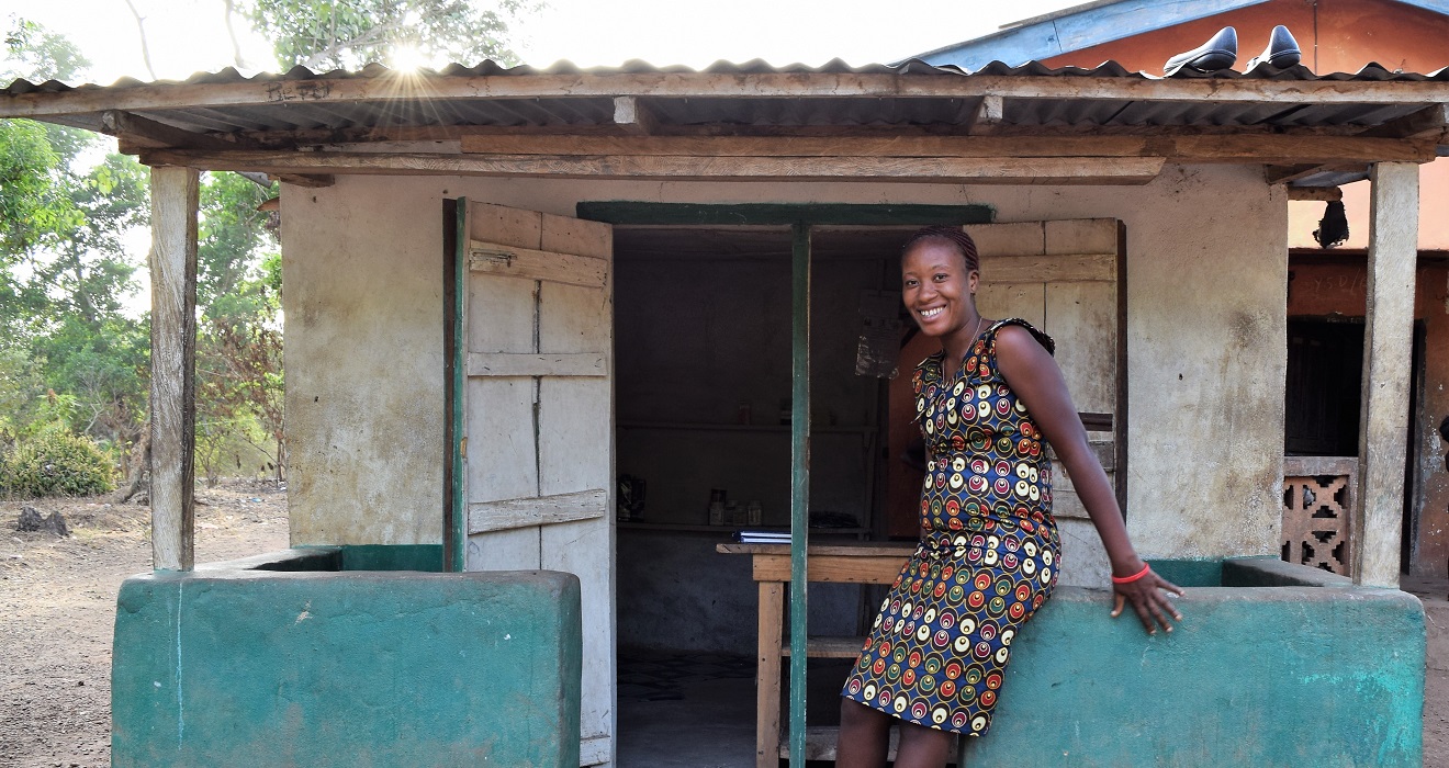 Woman in Sierra Leone in front of her house.